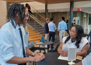 Catrina Douglas speaks with a student at a mixer on campus.